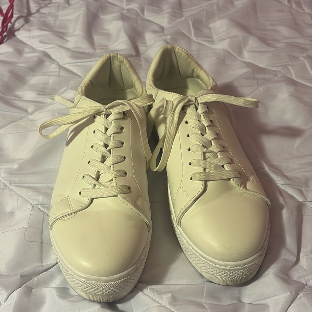 White sneakers with pearls on the back of the shoe.